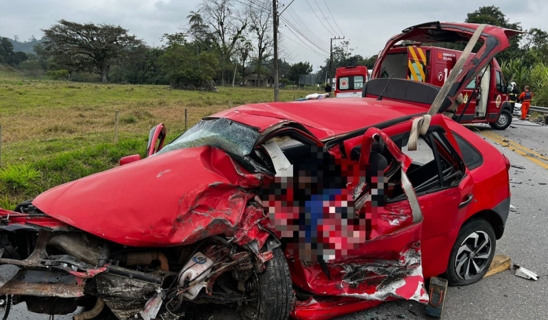 Carro vermelho com frente e lateral amassadas após colisão em rodovia de Ilhota, em SC. Motorista morreu preso às ferragens