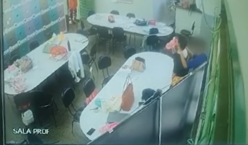 Imagem de câmera de segurança mostrando aluno mantendo professora com faca no pescoço dentro de sala