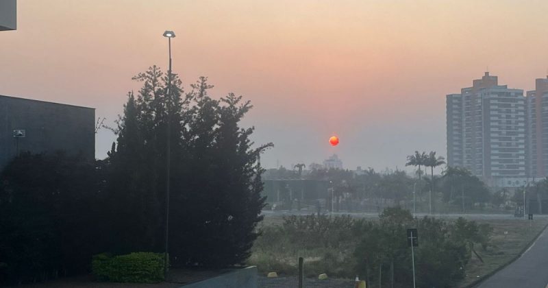 Sol avermelhado e céu coberto por fumaça em Criciúma