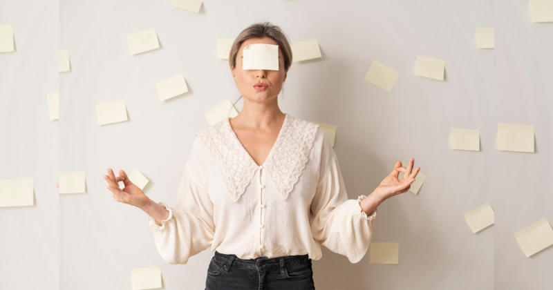 Mulher com muitos papéis ao seu redor e com um outro nos seus olhos