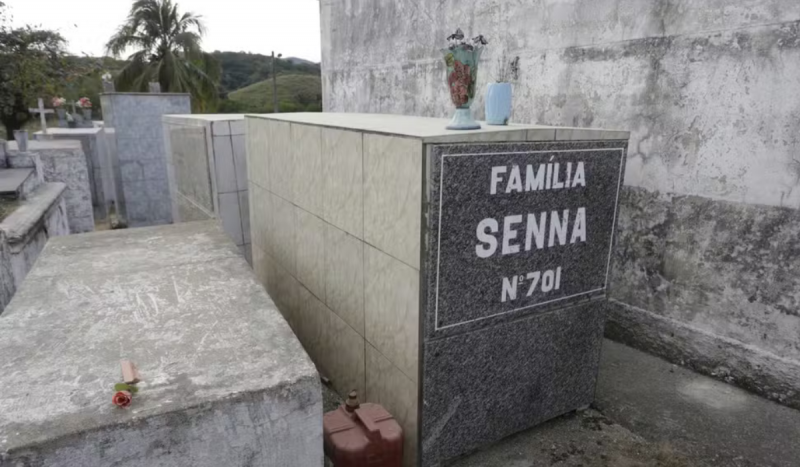 Túmulo cinza em cemitério escrito 'Família Senna' em branco