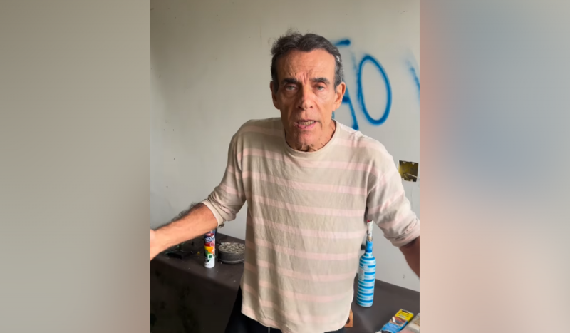 Ator Mário Gomes - homem branco, idoso, de cabelos grisalhos usando camisa listrada em tons de bege e marrom