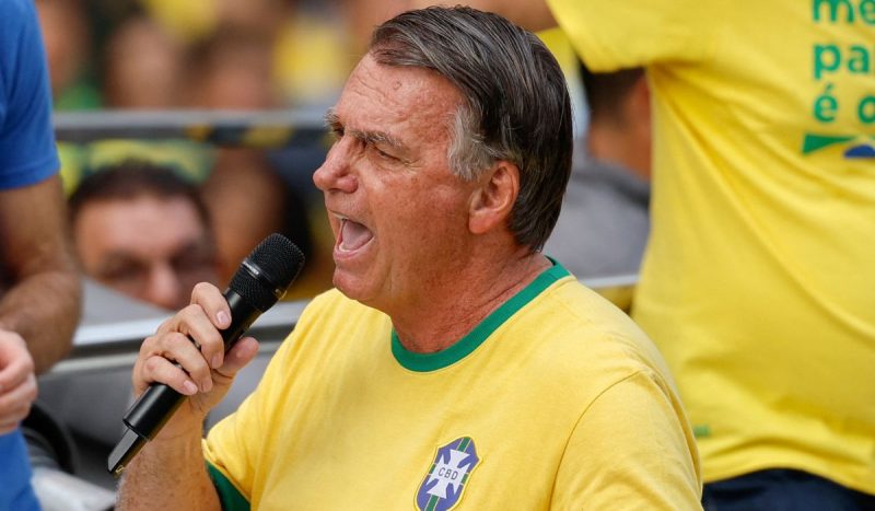 Bolsonaro aparece falando em microfone vestindo camiseta da seleção brasileira