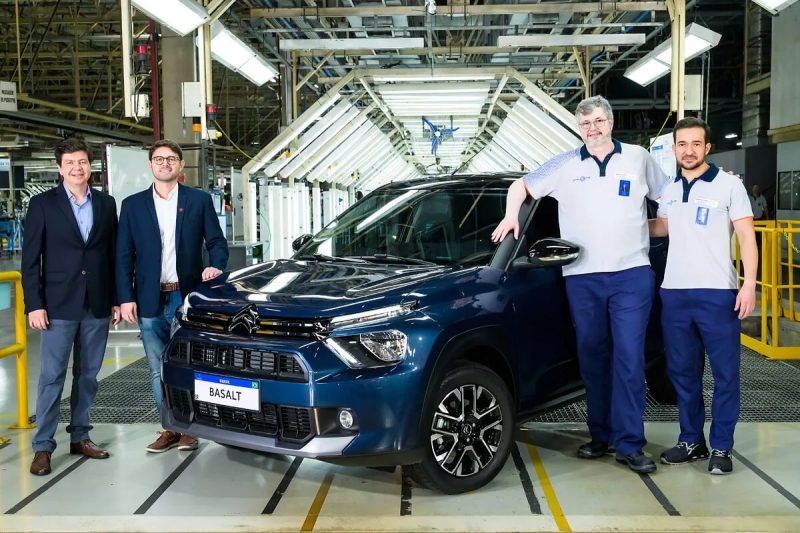 Citroen Basalt da cor azul, cercado por quatro executivos na fábrica da montadora