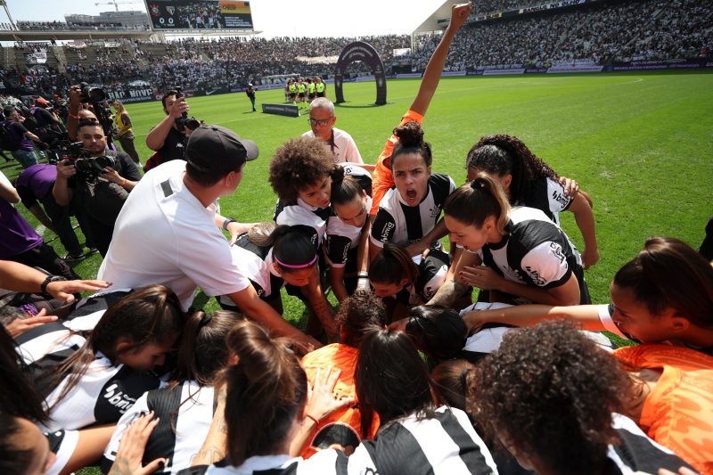 Corinthians com as suas jogadores celebrando a conquista no gramado do estádio