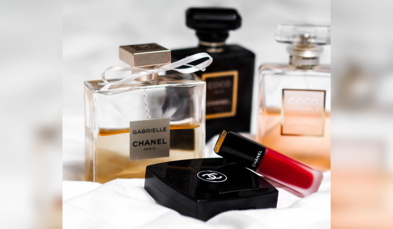 Cosméticos e perfumes da Chanel. Os itens estão dispostos em uma superfície branca, como um lençol