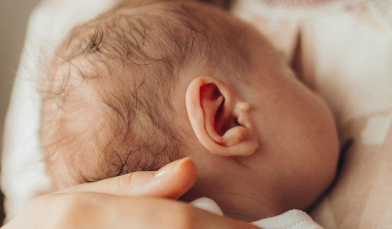 Bebê branco deitado em colo da mãe para ilustrar matéria sobre bronquiolite