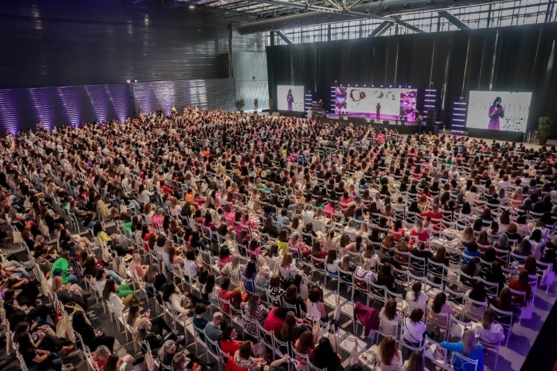 Na foto, grande auditório com centenas de mulheres que participam do Delas Summit