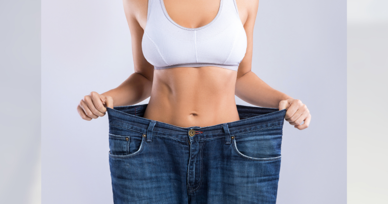 mulher segurando calça grande em volta de corpo