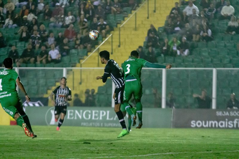 Jogador do Figueirense disputa bola no alto com zagueiro da Chapecoense, de camisa verde, no Estádio Orlando Scarpelli