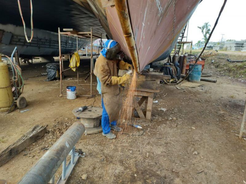 Na foto, homem soldando casco de navio. Soldador está entre vagas de emprego para início imediato.