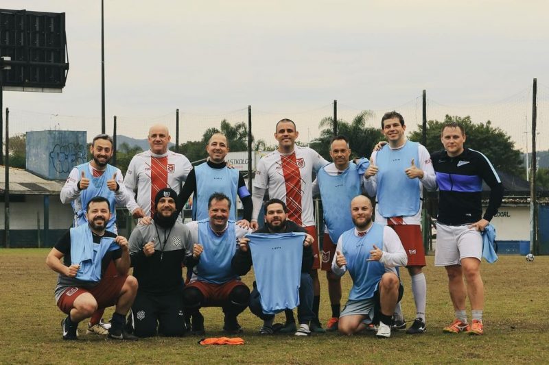 Jogadores da escolinha de futebol de adultos posados para uma foto no campo da gruta, na Trindade