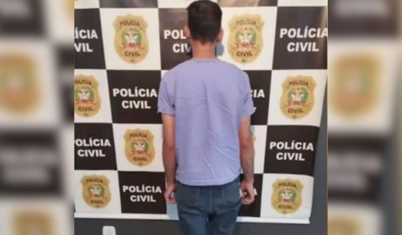 Homem, de costas para a foto, em momento da prisão