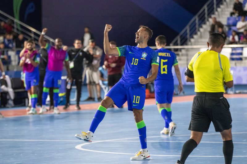 jogador de futsal pito com o uniforme azul da Seleção Brasileira na Copa do Mundo de Futsal comemorando o gol 