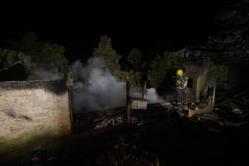 bombeiro fazendo rescaldo após incêndio que destruiu casa no interior de Chapecó 