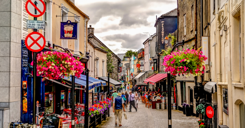 Rua na Irlanda cheia de flores e comércios