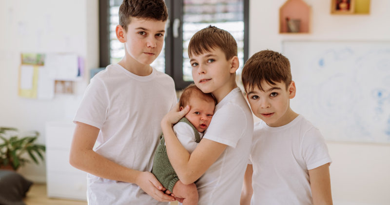 quatro filhos meninos em escadinha e um deles é um bebê