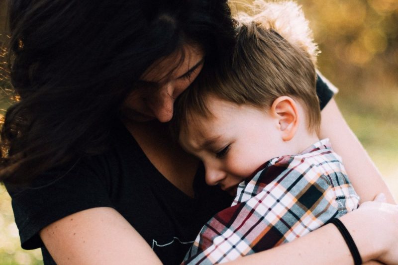 Filho chora no colo da mãe