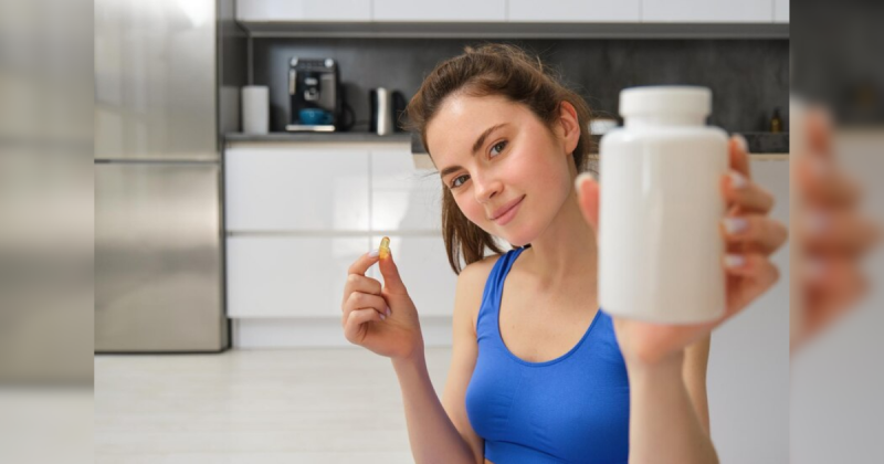 mulher segurando pote de vitamina com cropped azul