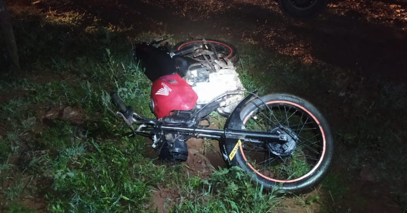 Moto do motociclista jogada no chão entre a grama