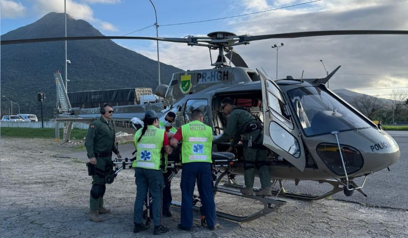 Socorro de helicóptero no Morro do Cambirela, socorristas aparecem colocando vítima na aeronave