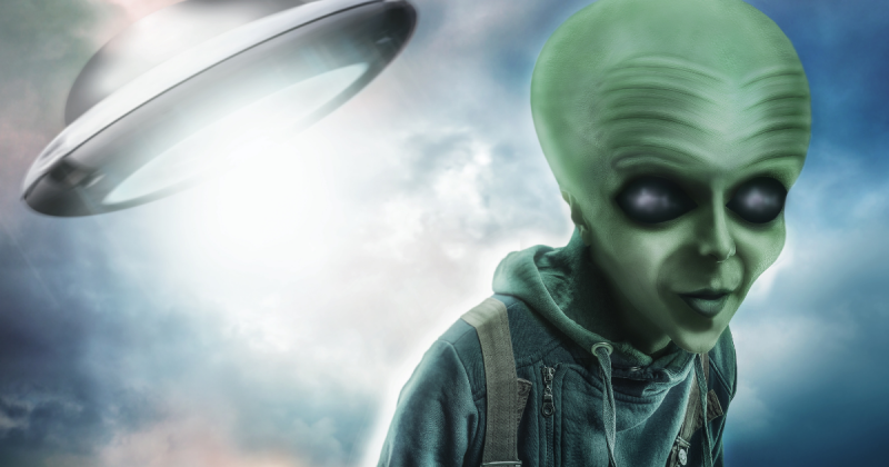 Detrás de él hay una ilustración de un extraterrestre y una nave espacial.