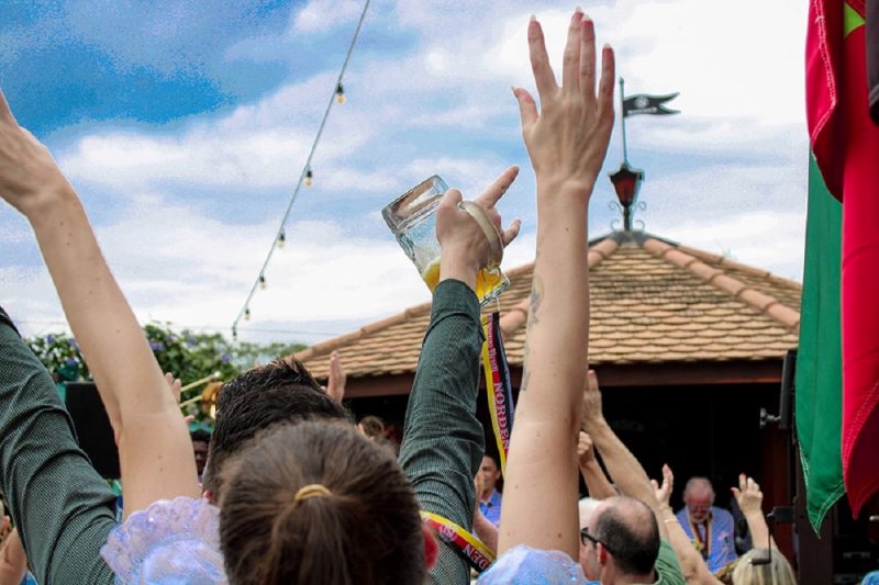 Imagem de divulgação de evento, onde mostra pessoas celebrando a Oktoberfest