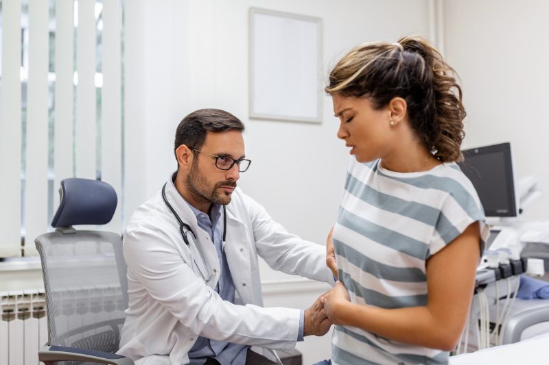 Mulher com dor no rim sendo analisada pelo médico 