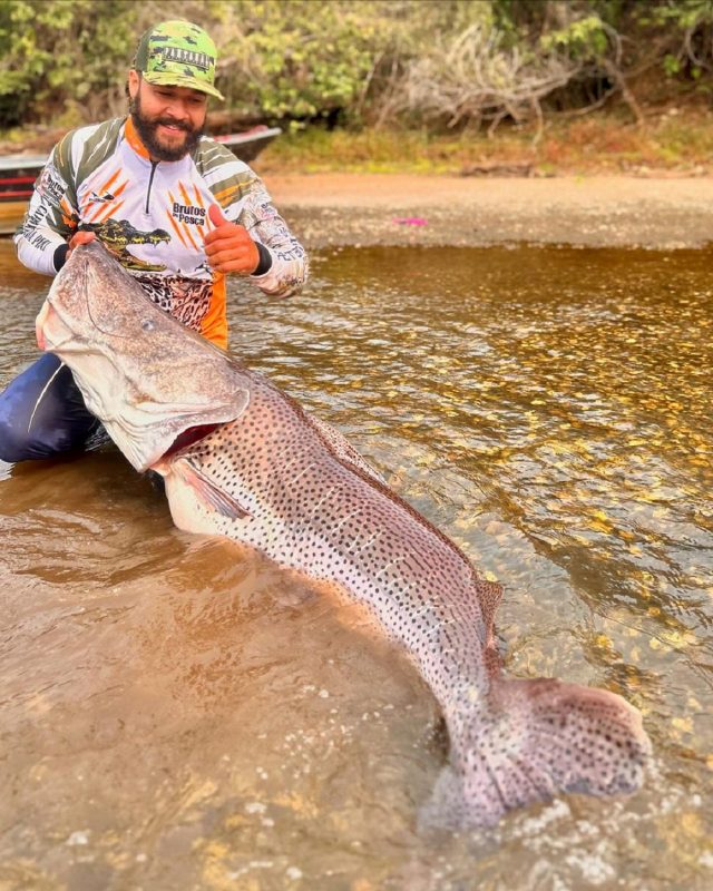 Romário Godez segurando o maior peixe-pintado já pescado no Brasil