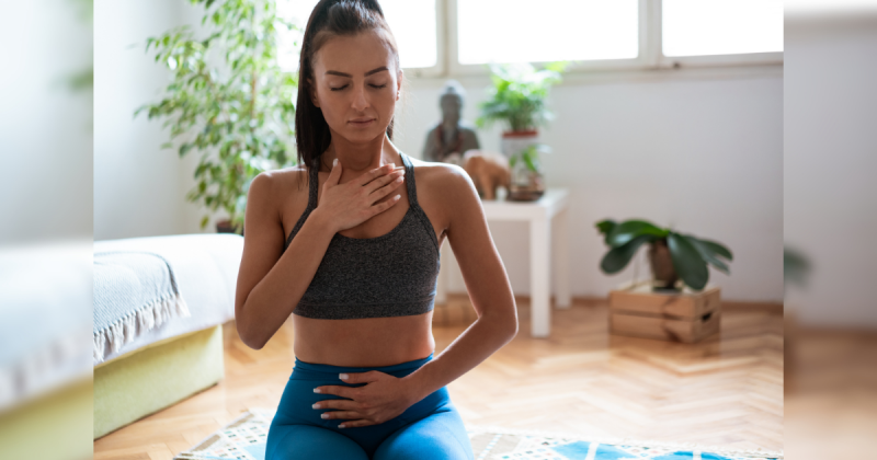 Mulher com mão na barriga treinando respiração