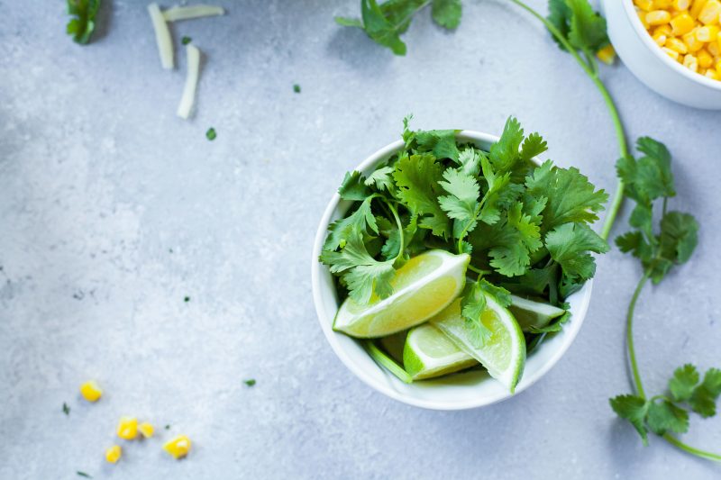 Erva (salsa) em uma vasilha com limões