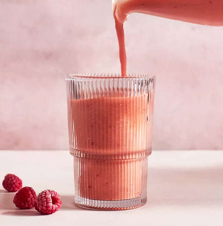 imagem mostra smoothie de frutas vermelhas e limão recém pronto