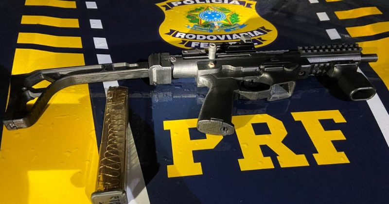 armas apreendidas em rodovias federais de SC, foto mostra submetralhadora apreendida em Tubarão em cima de capô de viatura da PRF