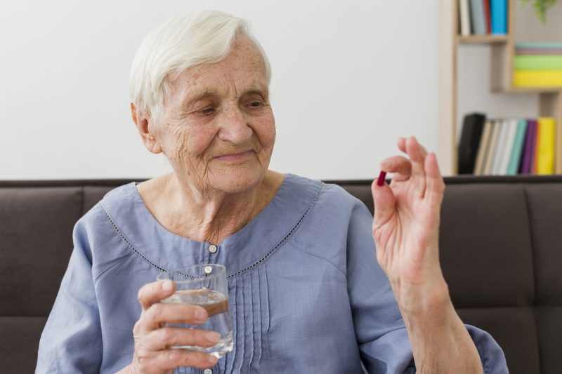 Idosa ingerindo sua vitamina da longevidade