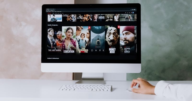 Mão em cima de teclado com tela aberta na Netflix