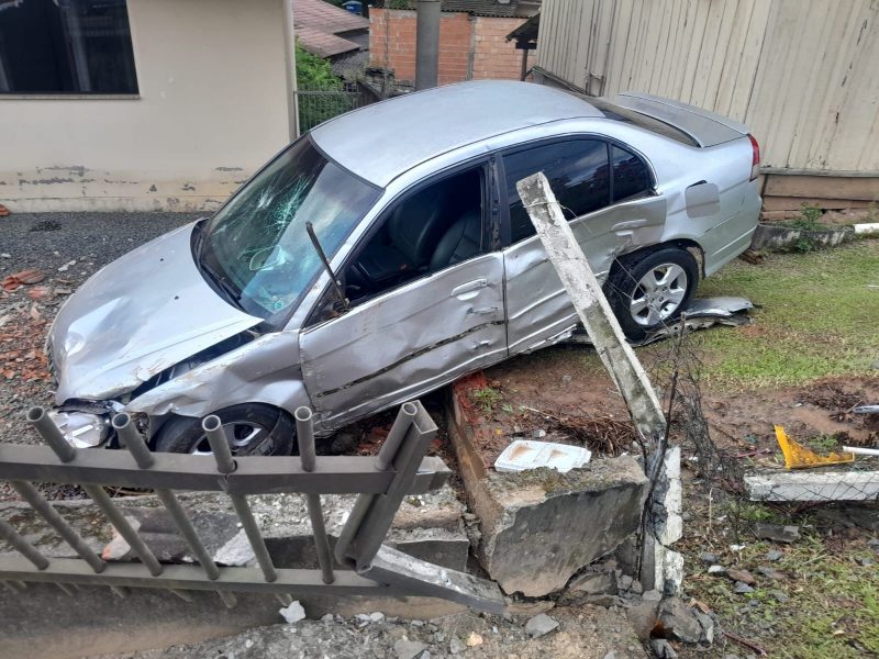 Um dos carros envolvidos no acidente caído sobre casa após colisão em Rodeio 