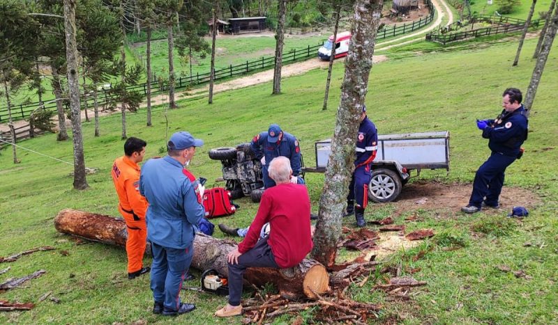 Acidente com quadriciclo deixa 1 morto em Rancho Queimado-SC - Pessoas ao redor de homem deitado no chão, ele é atendido por bombeiros de farda azul escuro