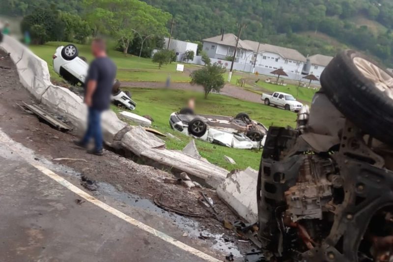 caminhão-cegonha tombado e carros espalhados