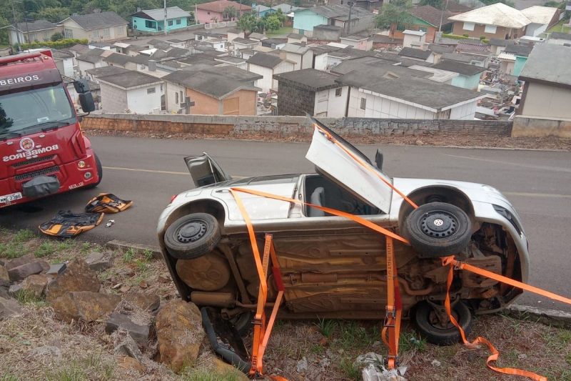 Carro capota e motorista fica preso por cinto de segurança.