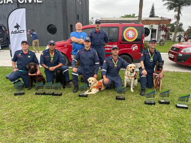 Binômios de SC reunidos com prêmios após conquista em competição Sul-Americana, sargento Marcos e cadela Luna estão ao fundo