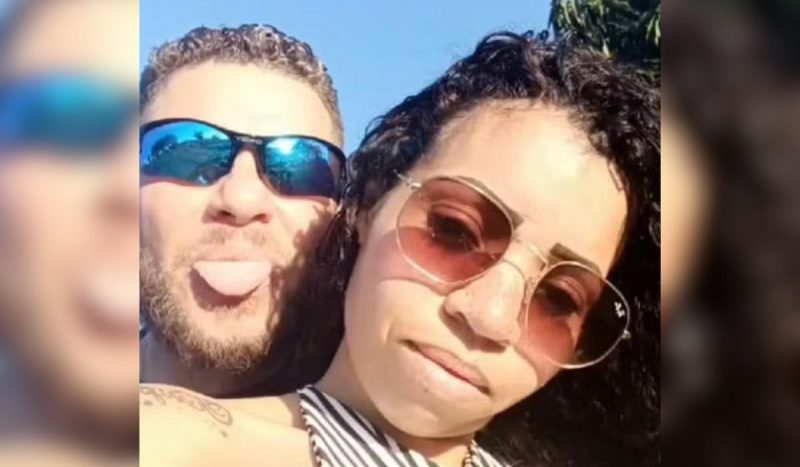 Homem e mulher brancos abraçados usando óculos de sol. Ele está com a língua para fora