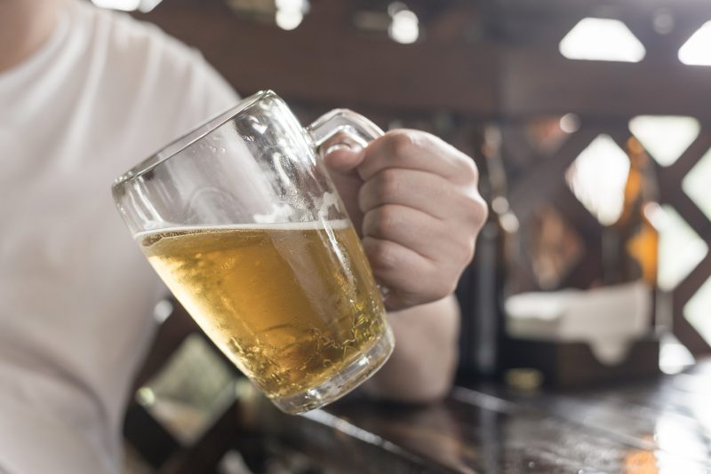 Homem segurando um copo de cerveja 