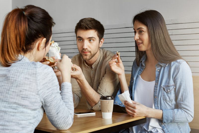 Amigos comendo um lanche enquanto conversam 