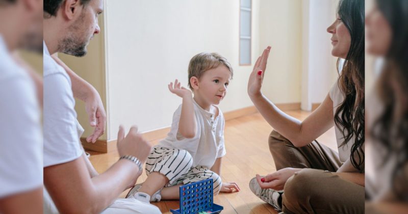 Criança batendo na mão de mulher enquanto homem olha sério