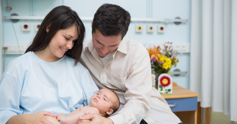 Pai e mãe segurando bebê em colo