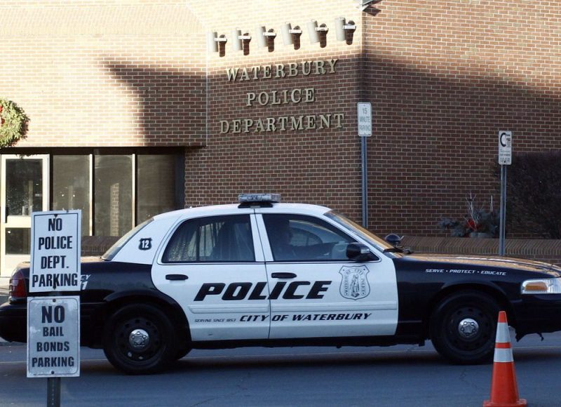 Fachada do Departamento de Polícia de Waterbury junto a um veículo da polícia