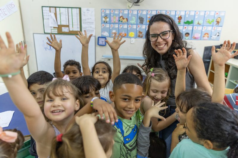 Foto mostra crianças sorrindo em uma escola que preza pela educação inclusiva