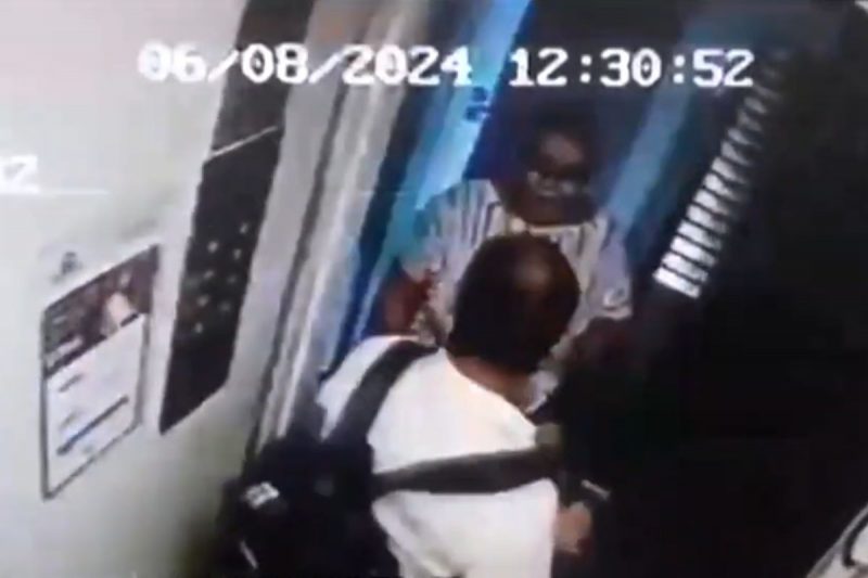 O porteiro Gildélio sai do elevador e a esposa Adriana entra em seguida