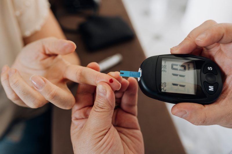 Enfermeira medindo glicemia de pacientes com diabetes em casa