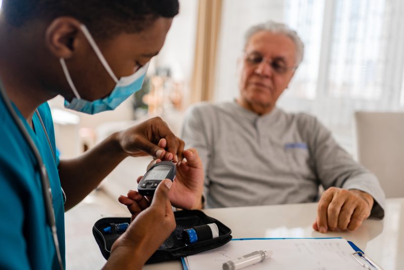 Enfermeira medindo níveis de glicose no sangue de pacientes com diabetes